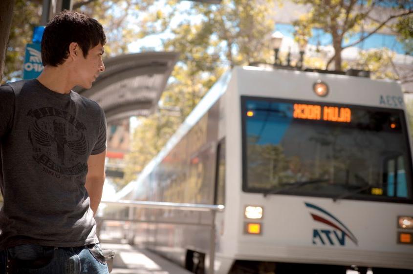 Young individual watching the VTA lightrail arrive.